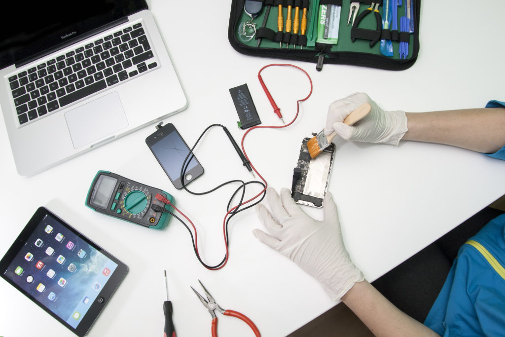 Prague, Czech Republic - NOVEMBER 30, 2014: Photo of the repair process of an iPhone 4. IPhone 4 are produced by Apple Computer, Inc..